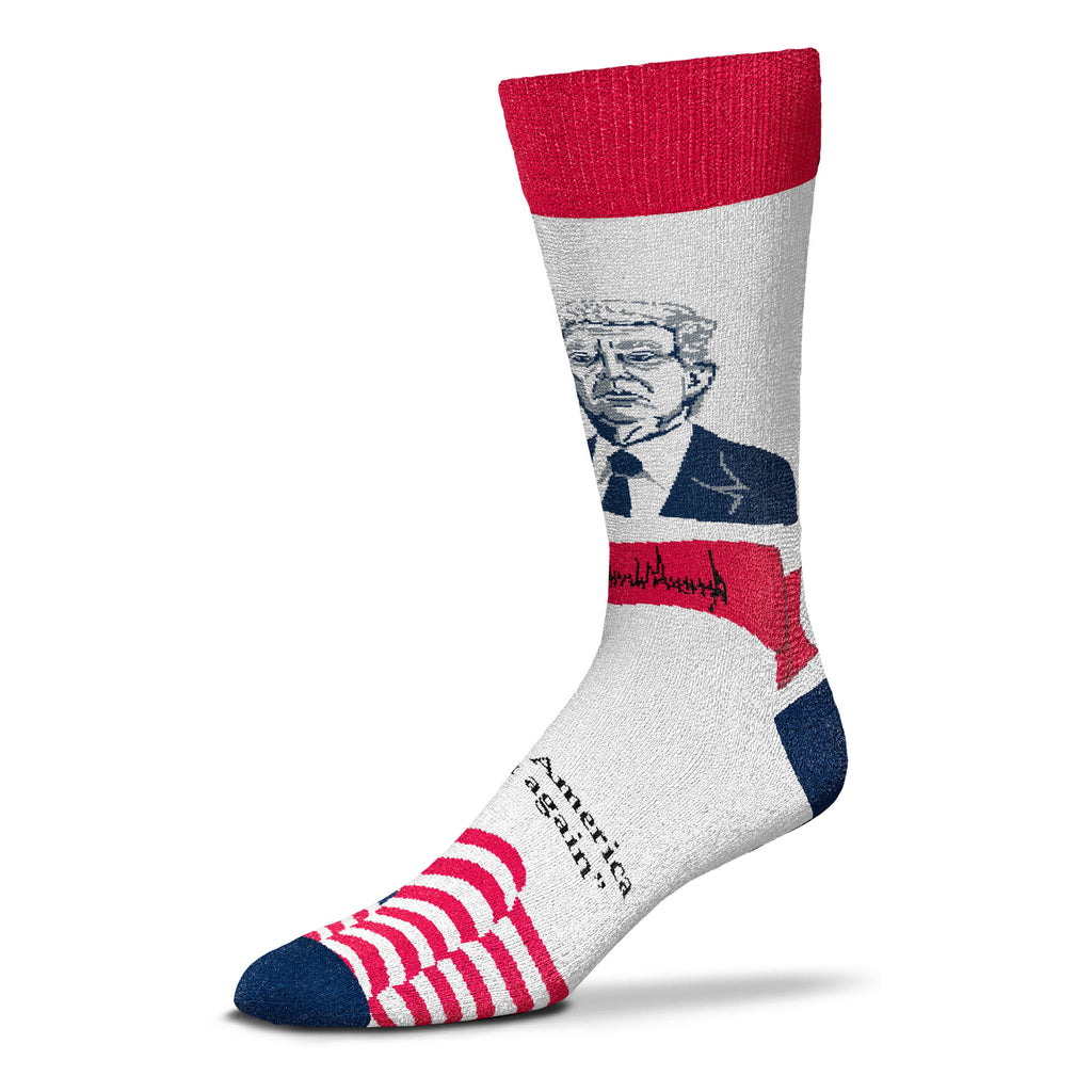For Bare Feet Makes Patriotic Selfie Donald Trump in Red White and Blue. President Trump is wearing a Blue Suit, White Shirt with a Blue Tie. Below in a Red bunting is President Trumps Signature. Below this is one of his signature phrases in Bold Blue Letters "Make America Great Again" On the top of Foot are The Blue Background with White Stars and the Red and White Stripes of The American Flag Waving. The Cuff is Red, the Heels and Toes are Blue.