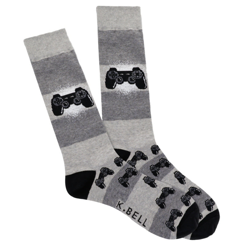 K Bell Mens Born to Game Sock is an easy Sock to wear and just show off a little bit about yourself to others maybe at work. Starting on a Heather Grey background with Black Heels and Toes the Sock also has Charcoal Grey. Midway down is one Controller in a bit of White splashed behind it. Then the pattern gathers up stacks of Controllers at the Heel moving down to the Toe.