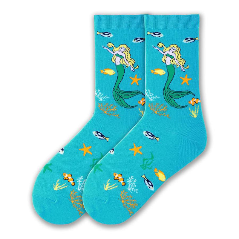 K Bell Mystic Mermaid is on a background of Turquoise.  The Mermaid has Yellow Hair, her Bralet and Fins and Eyes are Sea Green. She is around Coral in White and Orange. Fish and Starfish are around her too.