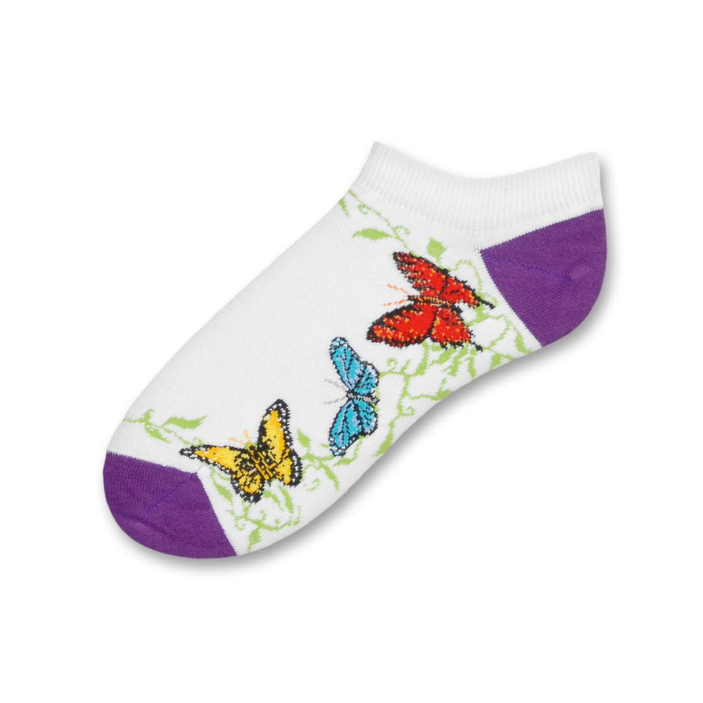 FBF Butterfly Friends Sock is a No Show Thin Style Sock with White background. The Heels and Toes are Purple. The Butterflies are Bright Yellow, Blue and Red. They fly over Green foliage.